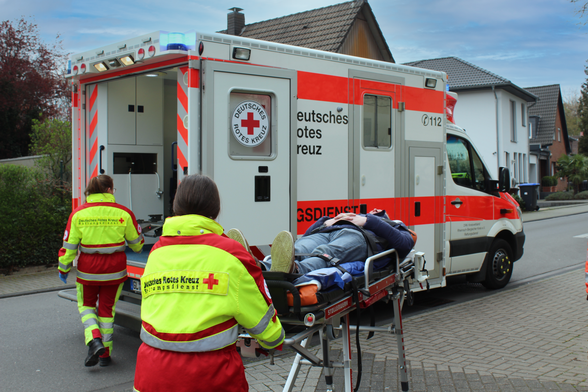 Ein Patient wird auf einer Trage zum bereits offenen RTW geschoben